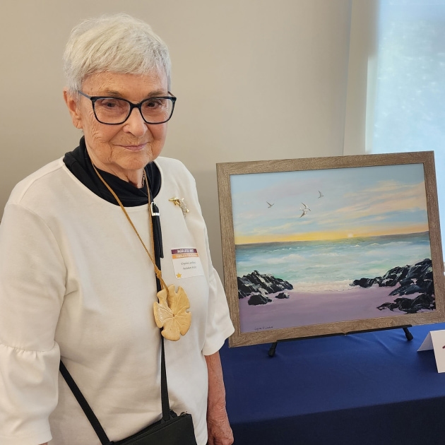 Virginia Laudano stands beside her painting called 